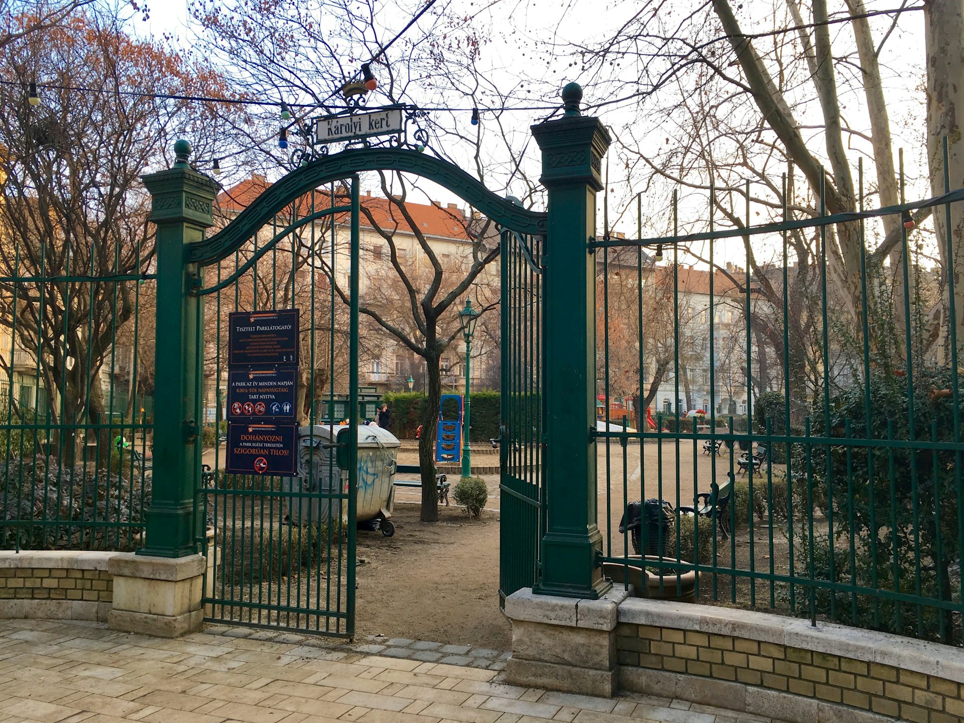 One of the front wrought-iron gates is ajar at Károly Garden, Budapest, Hungary