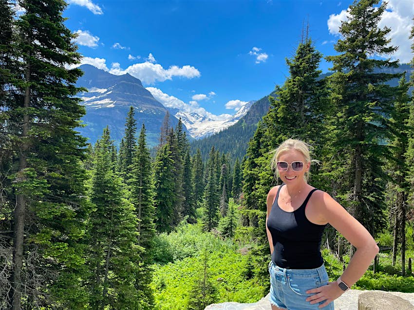 Melissa Yeager stands in front of a mountain scene. 