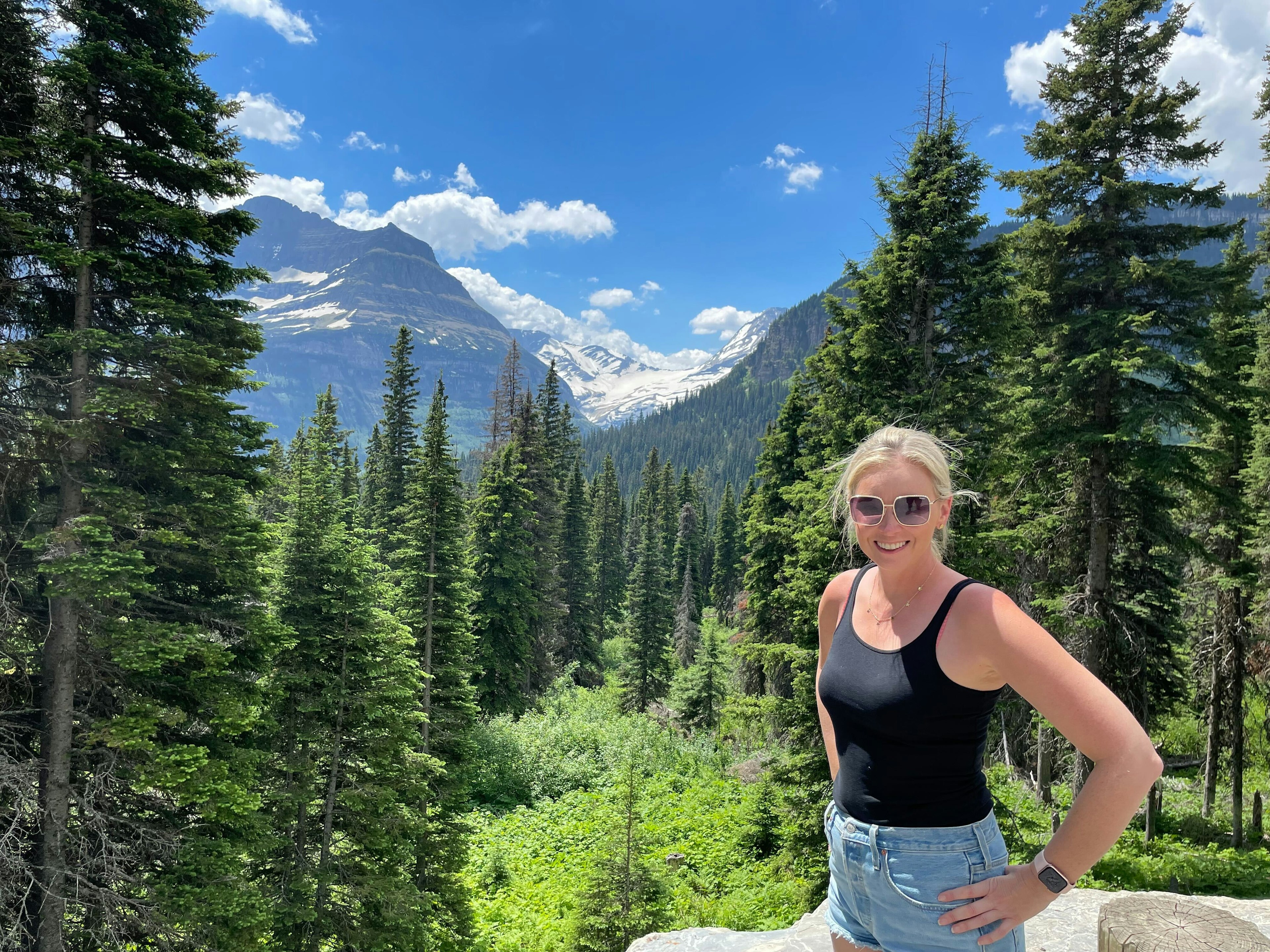 Melissa Yeager stands in front of a mountain scene.