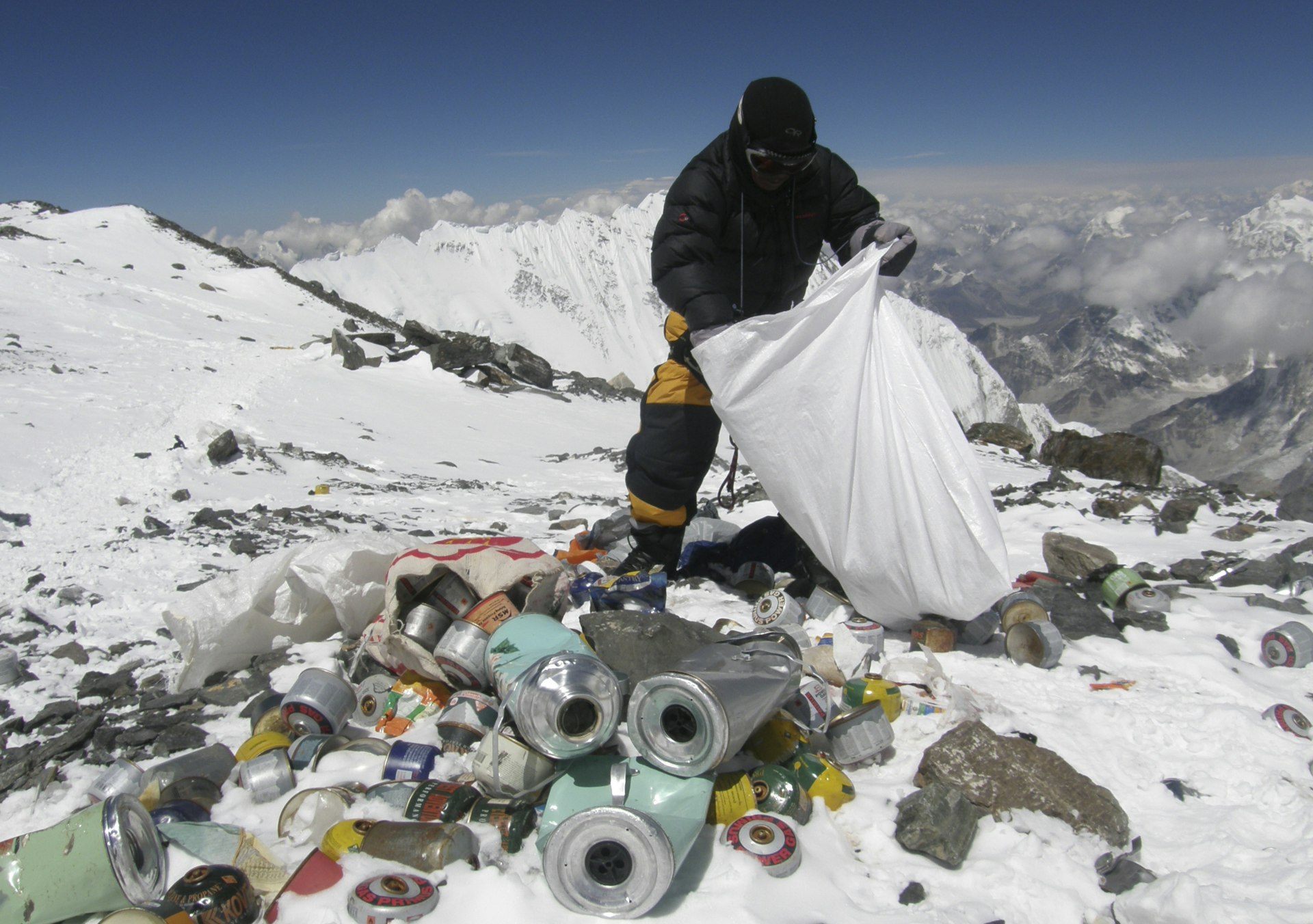 A Nepalese sherpa collecting garbage left by climbers