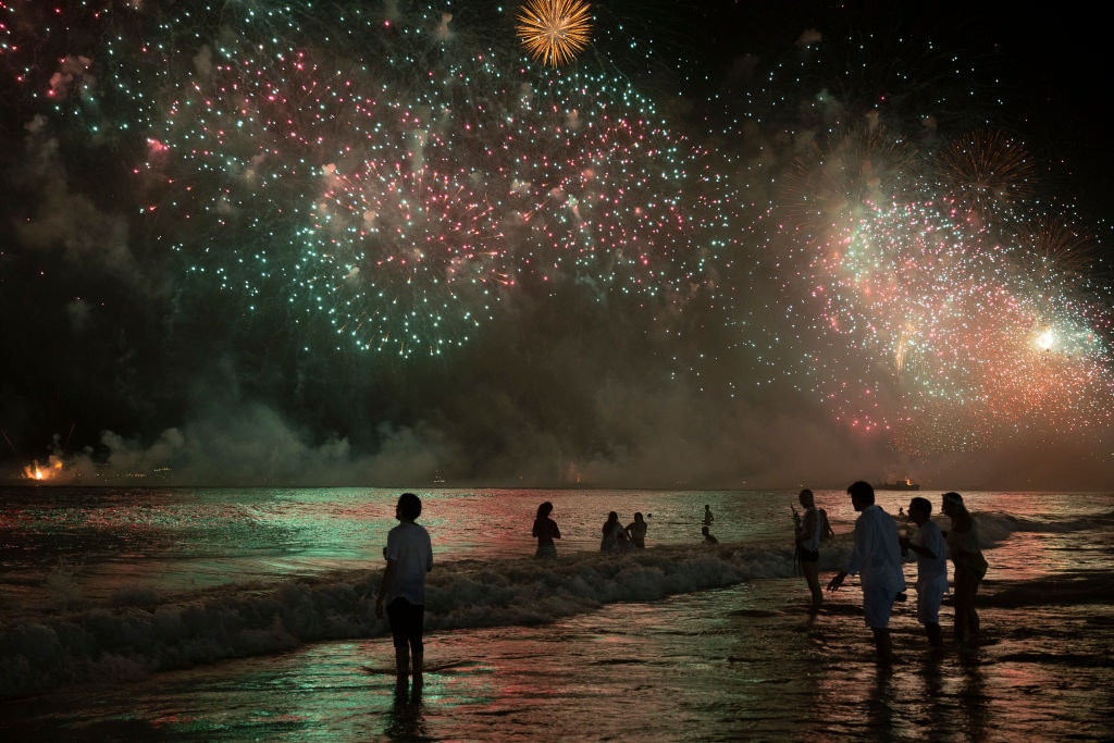 Revellers watch the NYE fireworks display on Copacabana beach