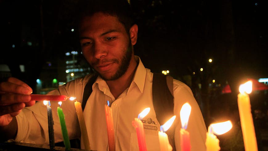 A man lights candles during the Night of Candles in Colombia