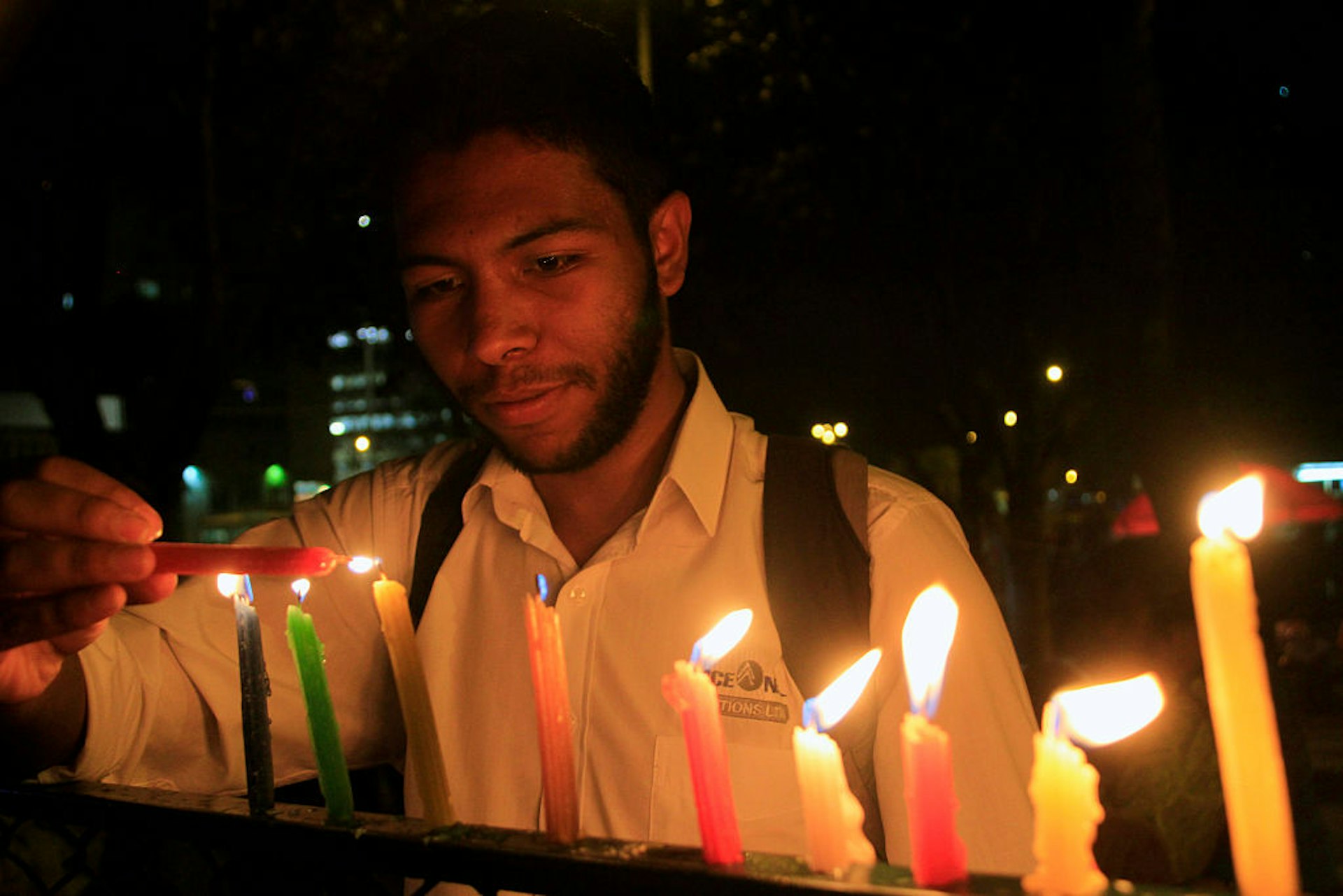 A man is lighting some candles during the "Night of Candles