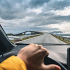 Tourist driving on the Atlantic Road with the famous Storseisundet bridge in the background