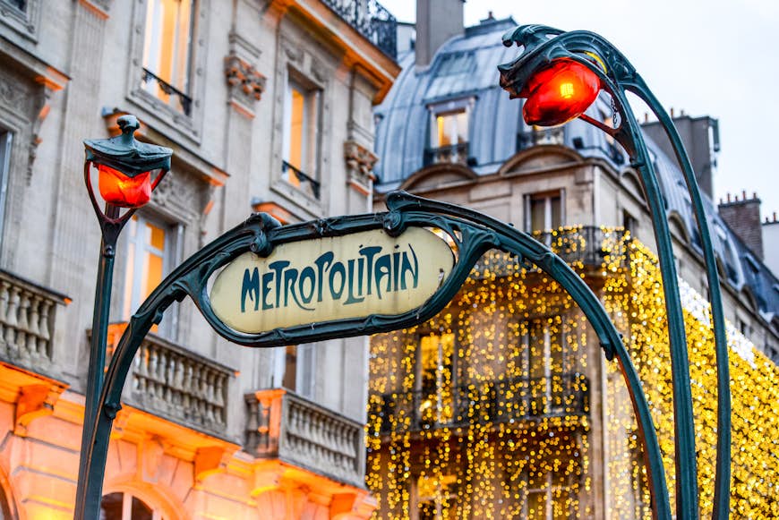 Paris Metro Sign with Christmas lights on surrounding buildings
