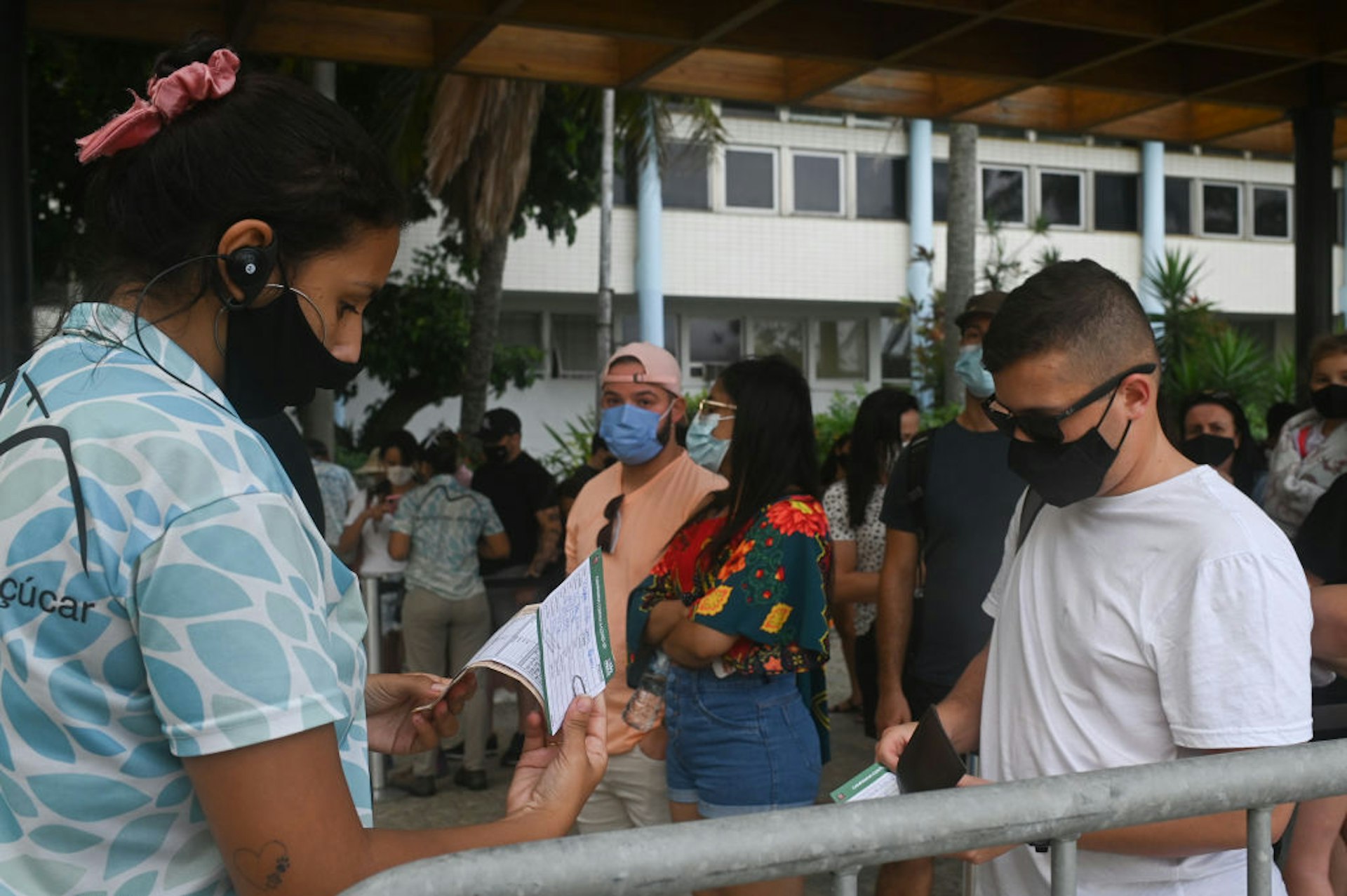 Tourists display vaccine verification at the Sugarloaf Mountain cable car entrance in Rio de Janeir