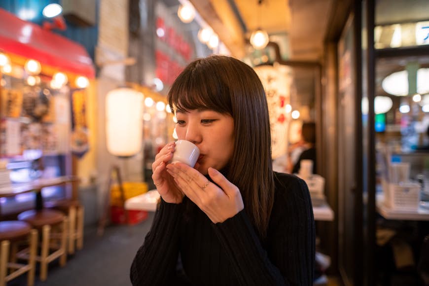 Ung kvinna dricker japanskt 