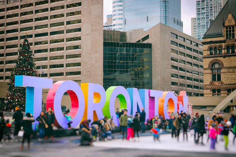 Lots of people are having fun by the colourful Toronto sign at Nathan Phillips Square.