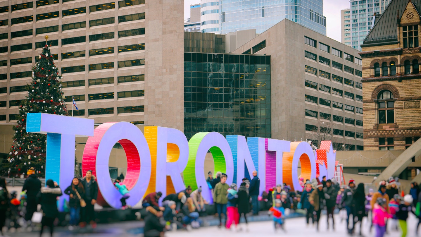 Lots of people are having fun by the colourful Toronto sign at Nathan Phillips Square.