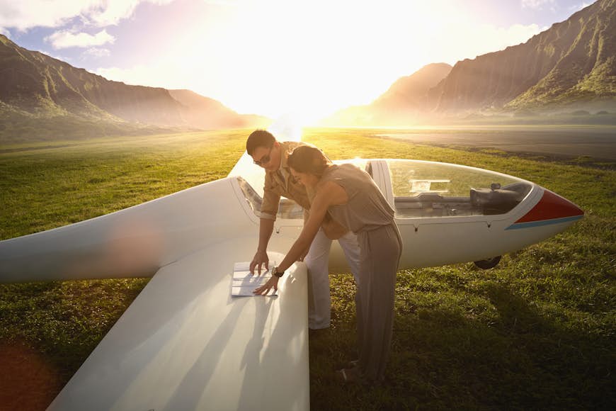Couple reading a map on a glider airplane in Hawaii