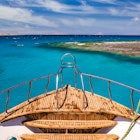 Cruise boat in the clear water near coral reef.
