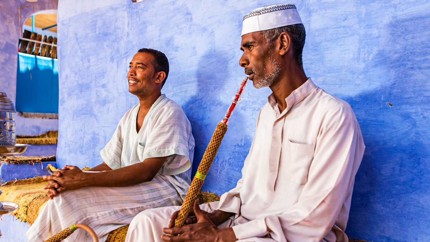 "Two Muslim men smoking sheesha (waterpipe) in Nubian Village near Aswan, Southern Egypt, Africa."