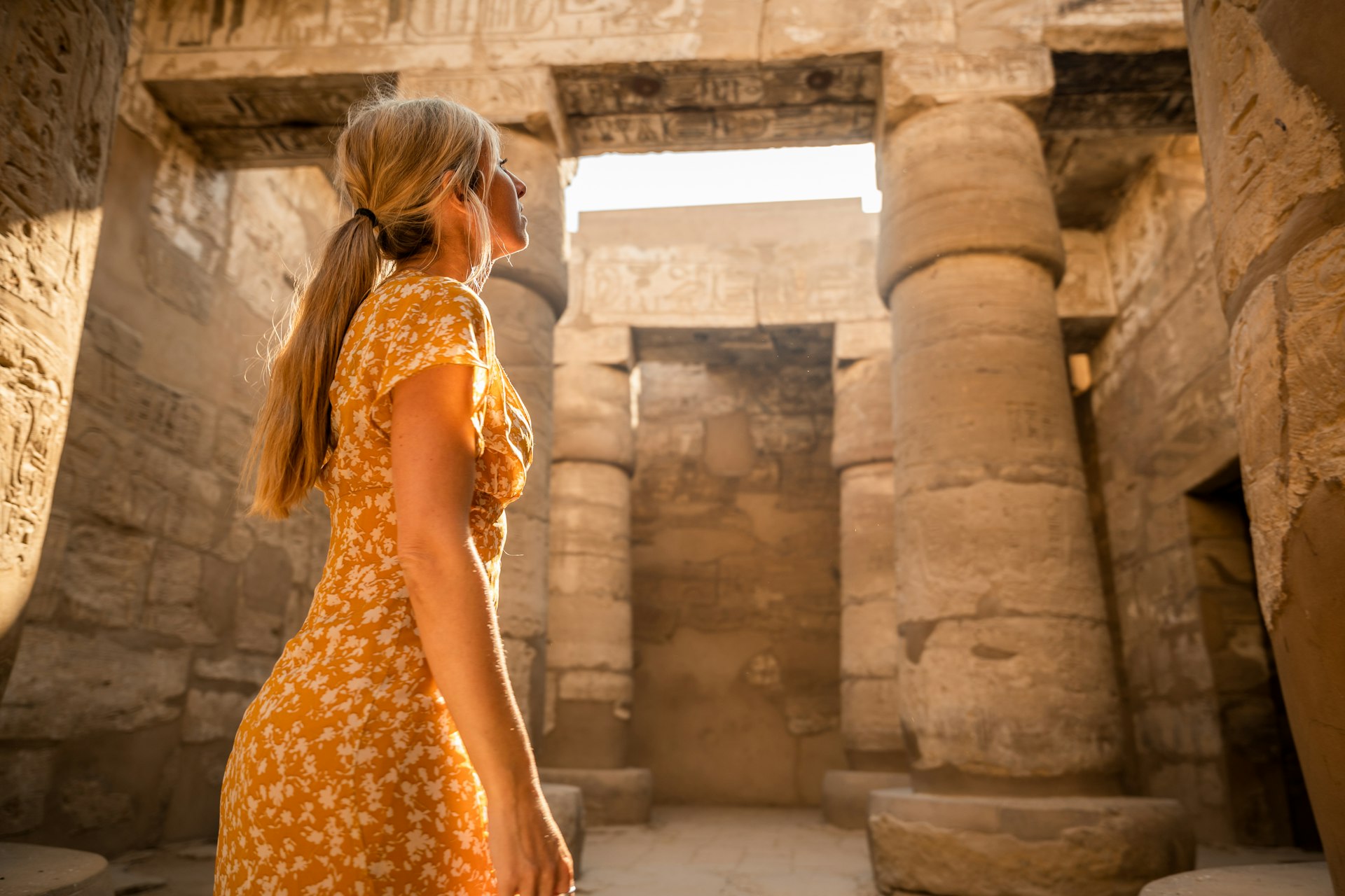 A woman looking at the columns of an ancient temples in Luxor