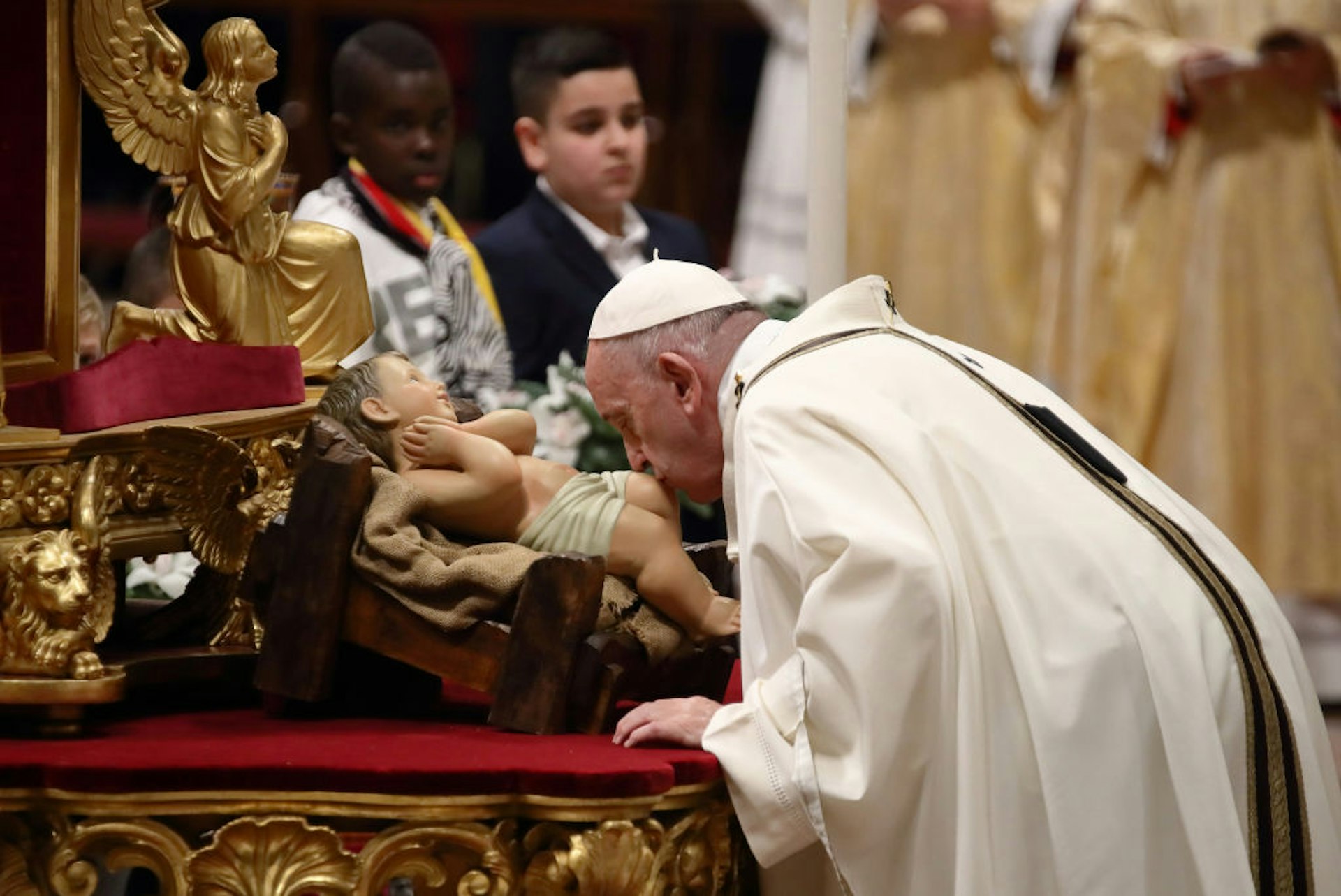 Pope Francis kissing a statue of Jesus during midnight mass on Christmas Eve in St Peter's Basilicam