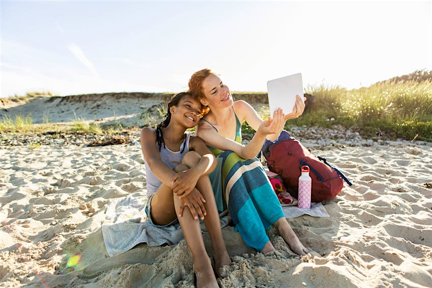 Μια χαμογελαστή μητέρα και κόρη βγάζουν selfie στην παραλία της Σουηδίας