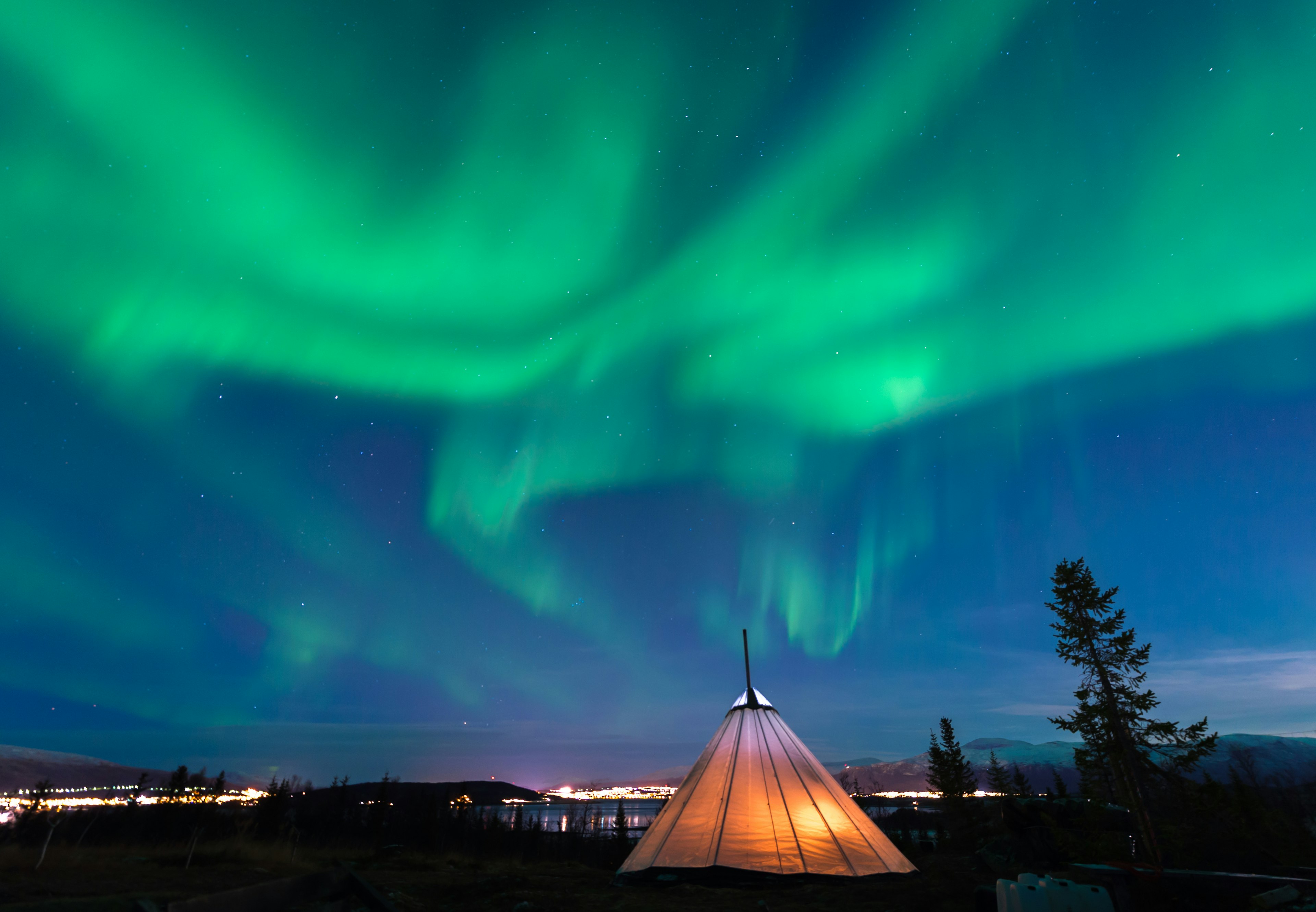 Traditional Sami reindeer-skin tents (lappish yurts) in Troms region of Norway with the northern lights in the skyional,Sami,Reindeer-skin,Tents,(lappish,Yurts),In,Troms,Region,Of