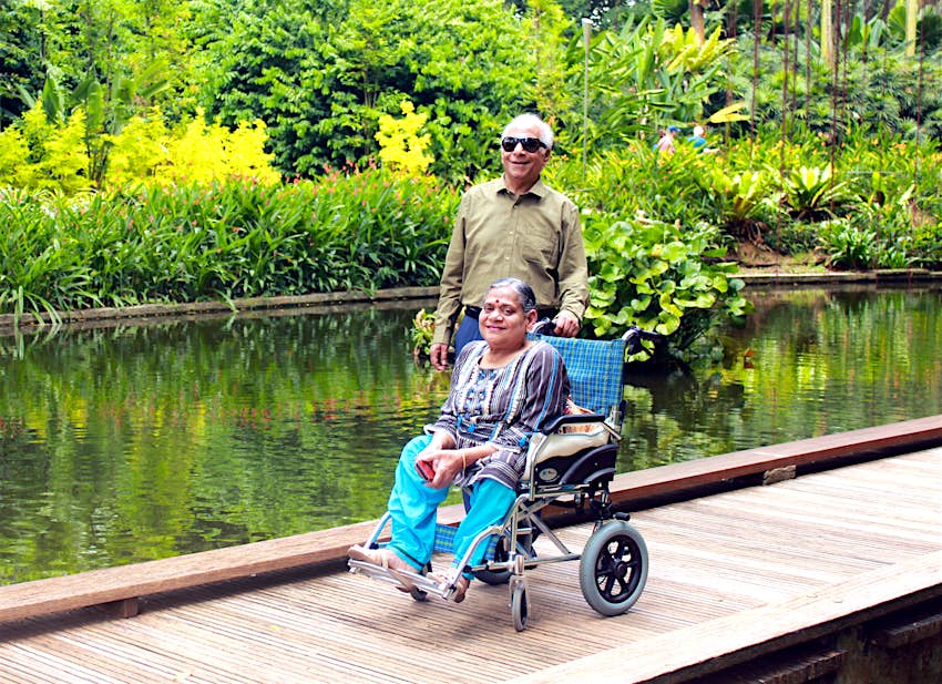 planeta-capacitados-padres-nov-2021.jpg Los padres de Arora posando en un puente con un fondo tropical.