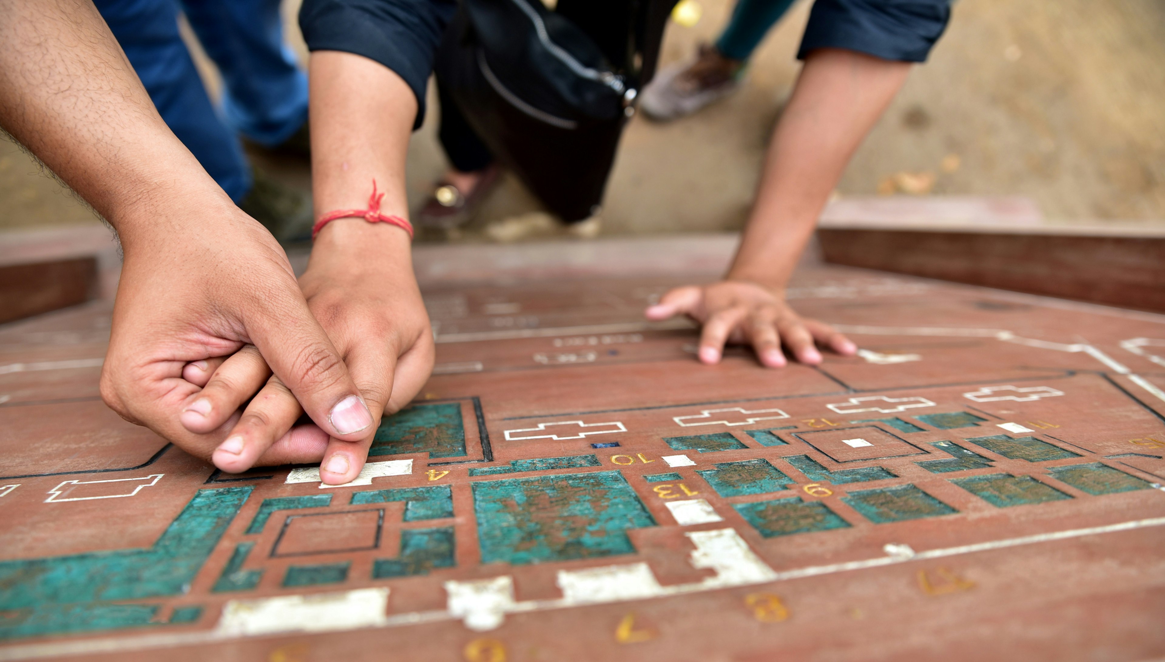 One person's hand guiding another's across a topographical map.