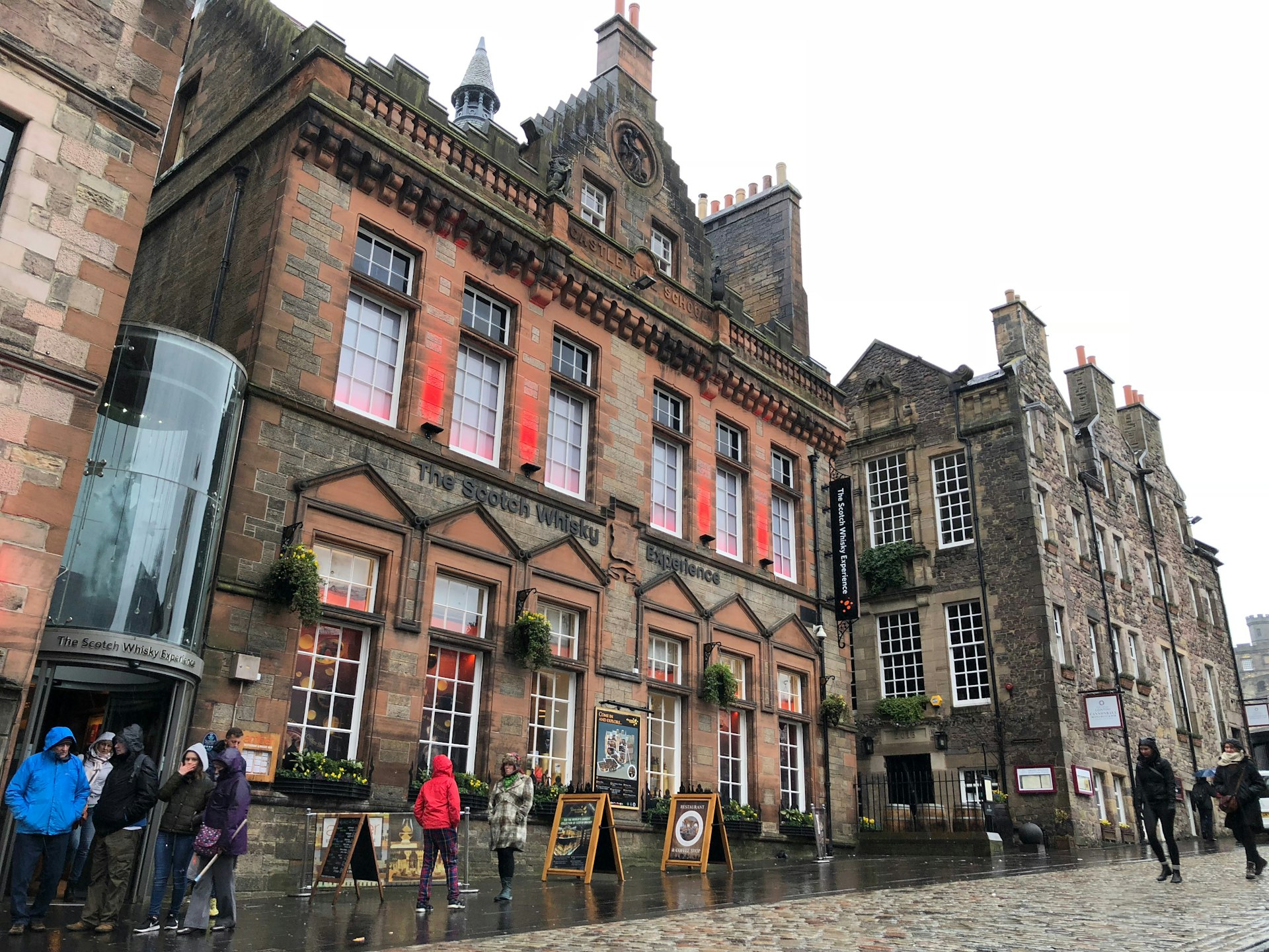 People walking along a street in Edinburgh on a wet rainy day