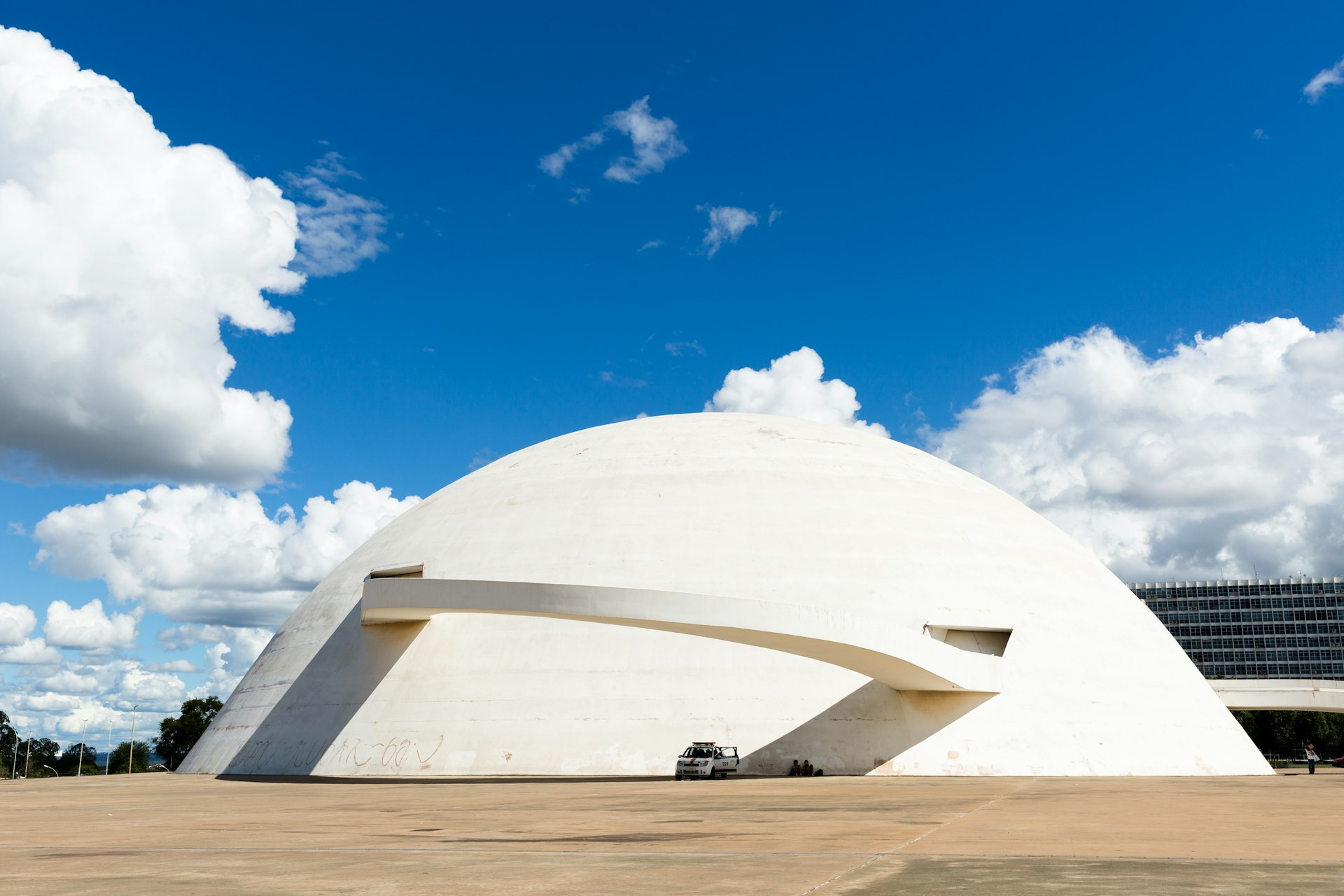 The white-domed exterior of Oscar Niemeyer’s National Museum in Brasília, under a blue sky with clouds