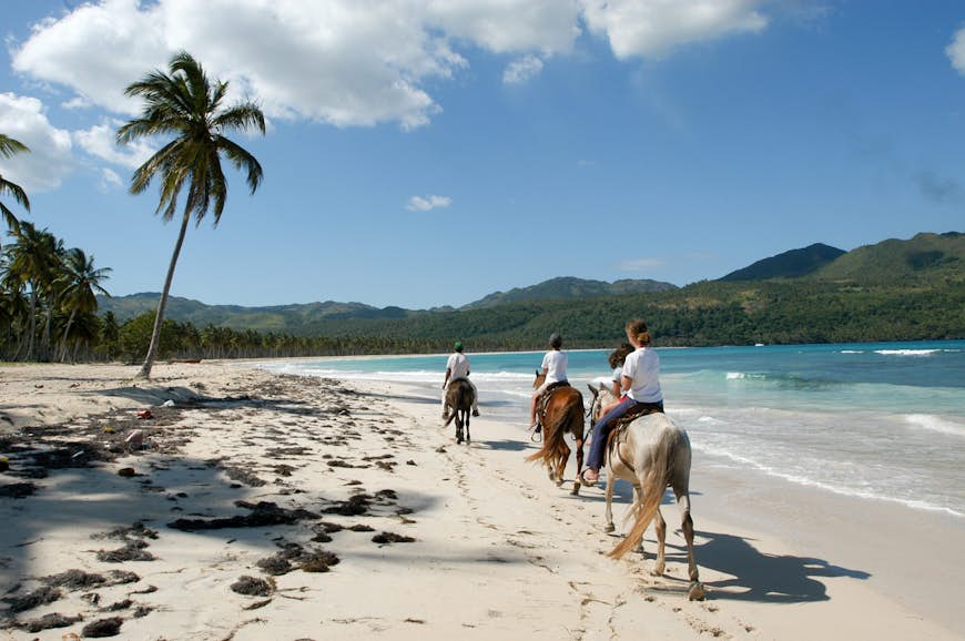 Family riding horses on the beach at Rincon, Dominican Republic
