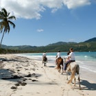 Las Galeras, Dominican Republic - 25 january 2002: people riding horses on the beach of Rincon near Las Galeras on Dominican Republic