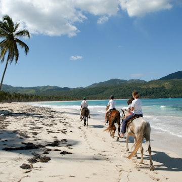 Las Galeras, Dominican Republic - 25 january 2002: people riding horses on the beach of Rincon near Las Galeras on Dominican Republic