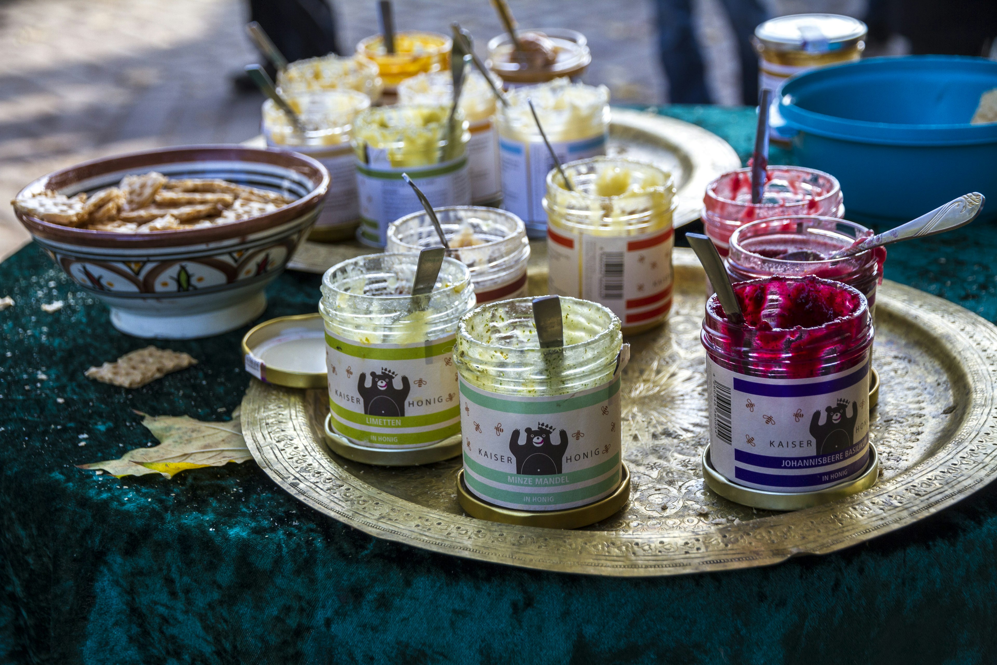 Colorful jars of jam on a metal tray in Flohmarkt im Mauerpark market in Berlin,