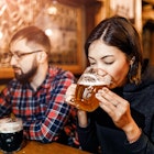 A woman and her friends try freshly brewed authentic Czech beer in a tavern in Prague