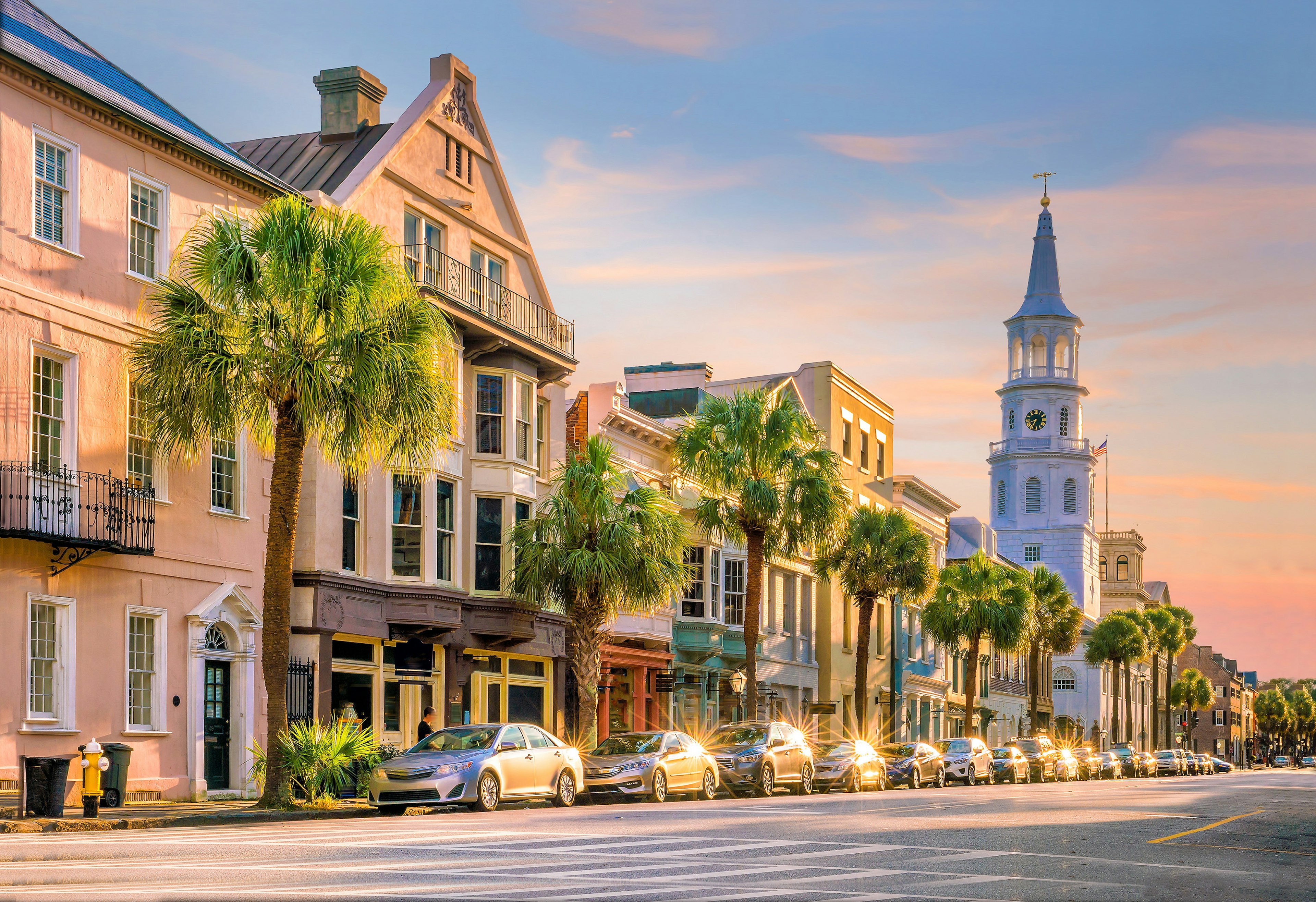 The setting sun reflects off parked cars in historic downtown Charleston