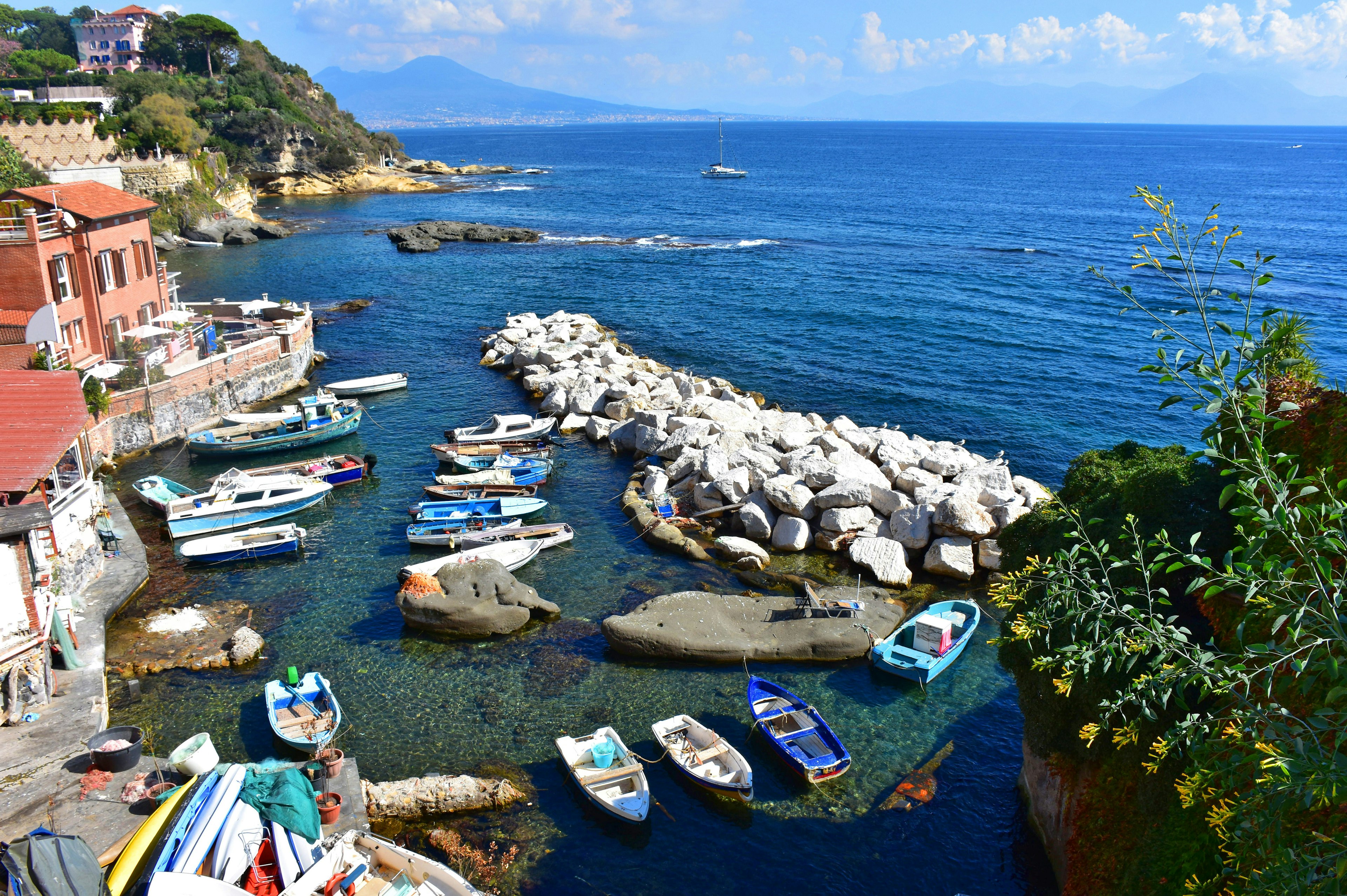 Boats docked at the small port of Marechiaro with Vesuvius in the background Naples Italy