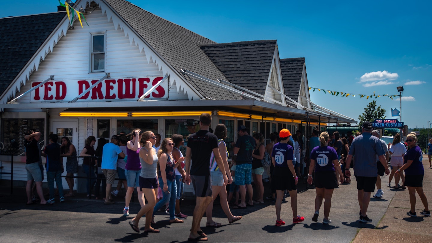 Saint Louis, MO—June 29, 2019; patrons standing outside in lines at service windows at Ted Drews frozen custard and ice cream shop on Route 66 in St. Louis Missouri during summer