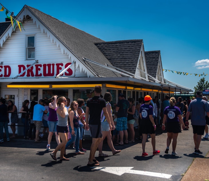 Saint Louis, MO—June 29, 2019; patrons standing outside in lines at service windows at Ted Drews frozen custard and ice cream shop on Route 66 in St. Louis Missouri during summer