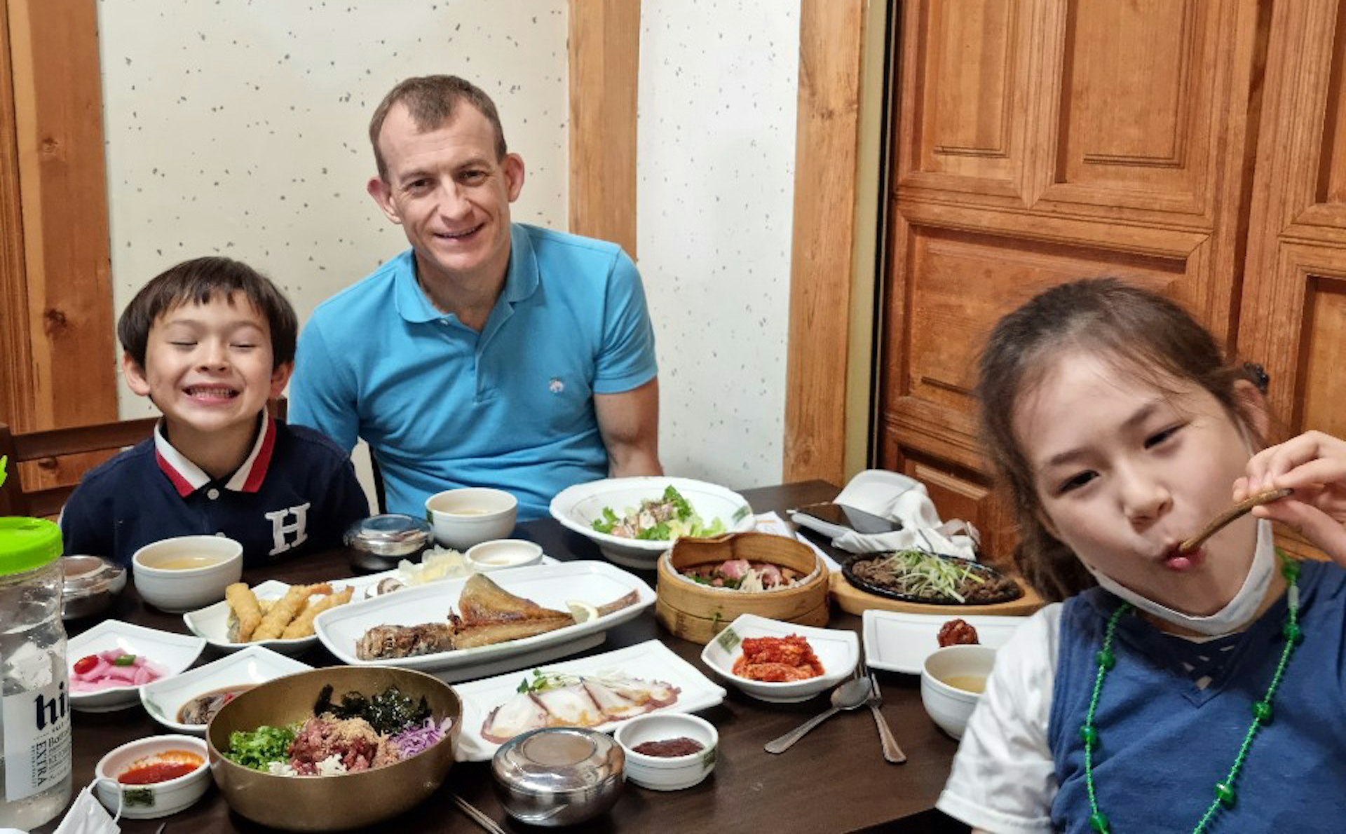 A father and his children enjoying a Korean meal