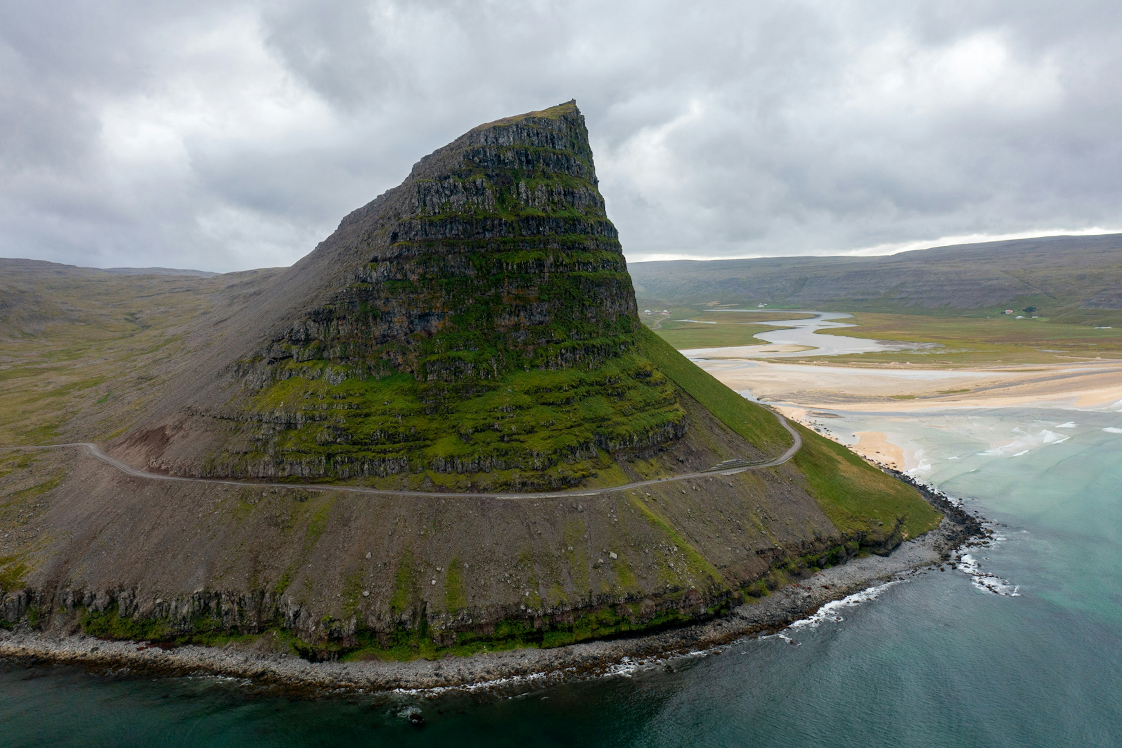 Aerial shot of a peninsula by the sea.