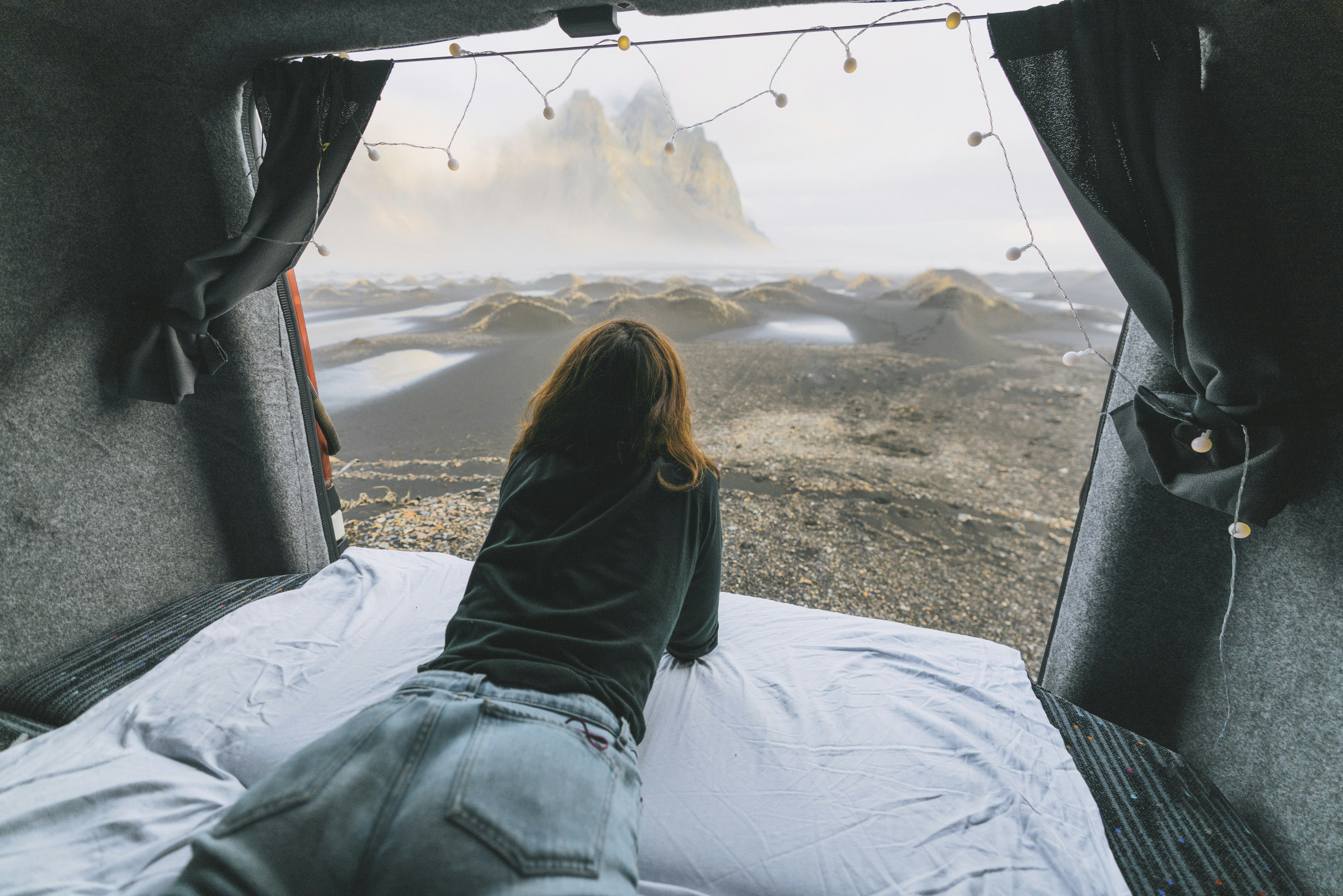 Woman looking at mountains from camper van