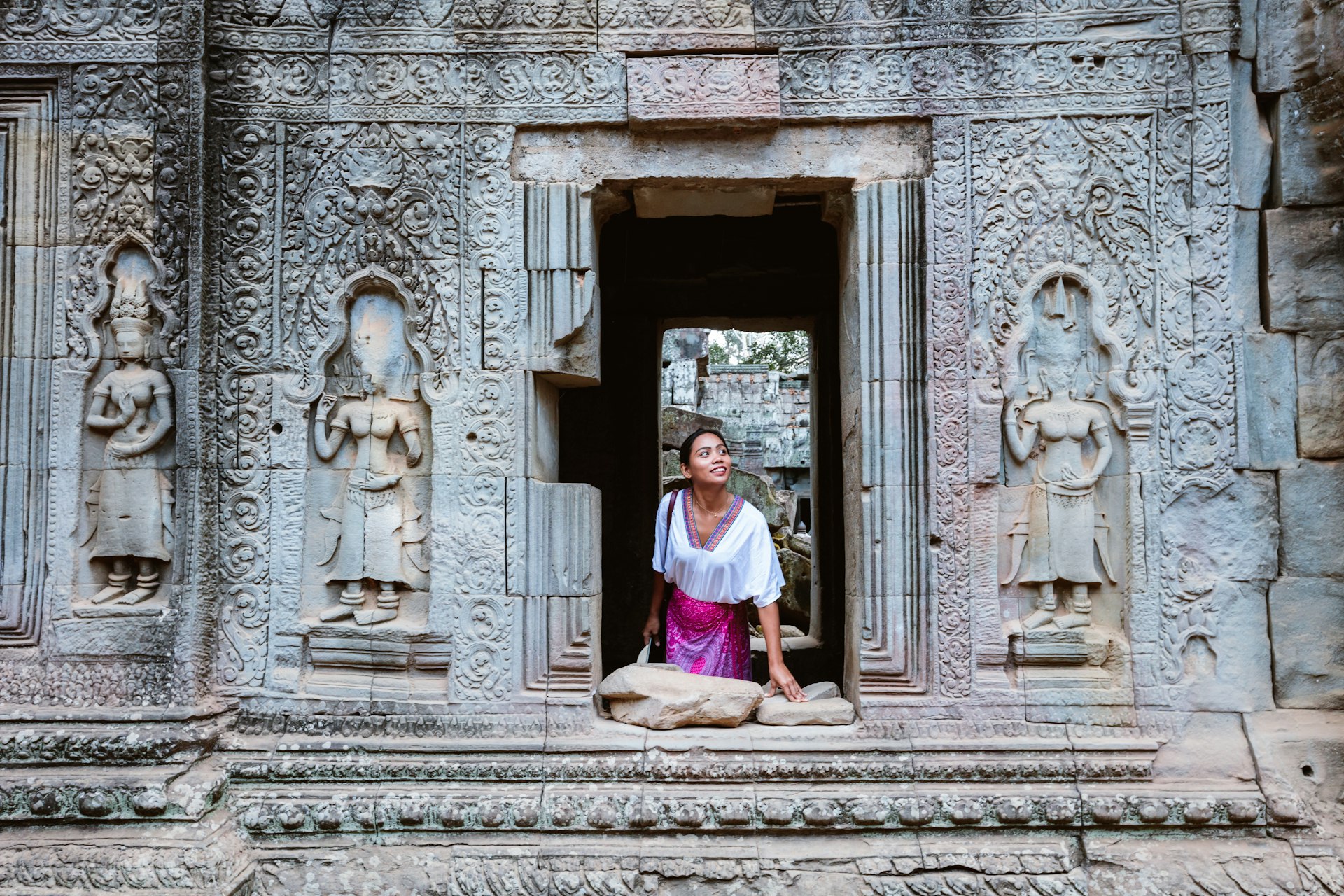 Woman looking out of a window in a temple, Angkor, Cambodia