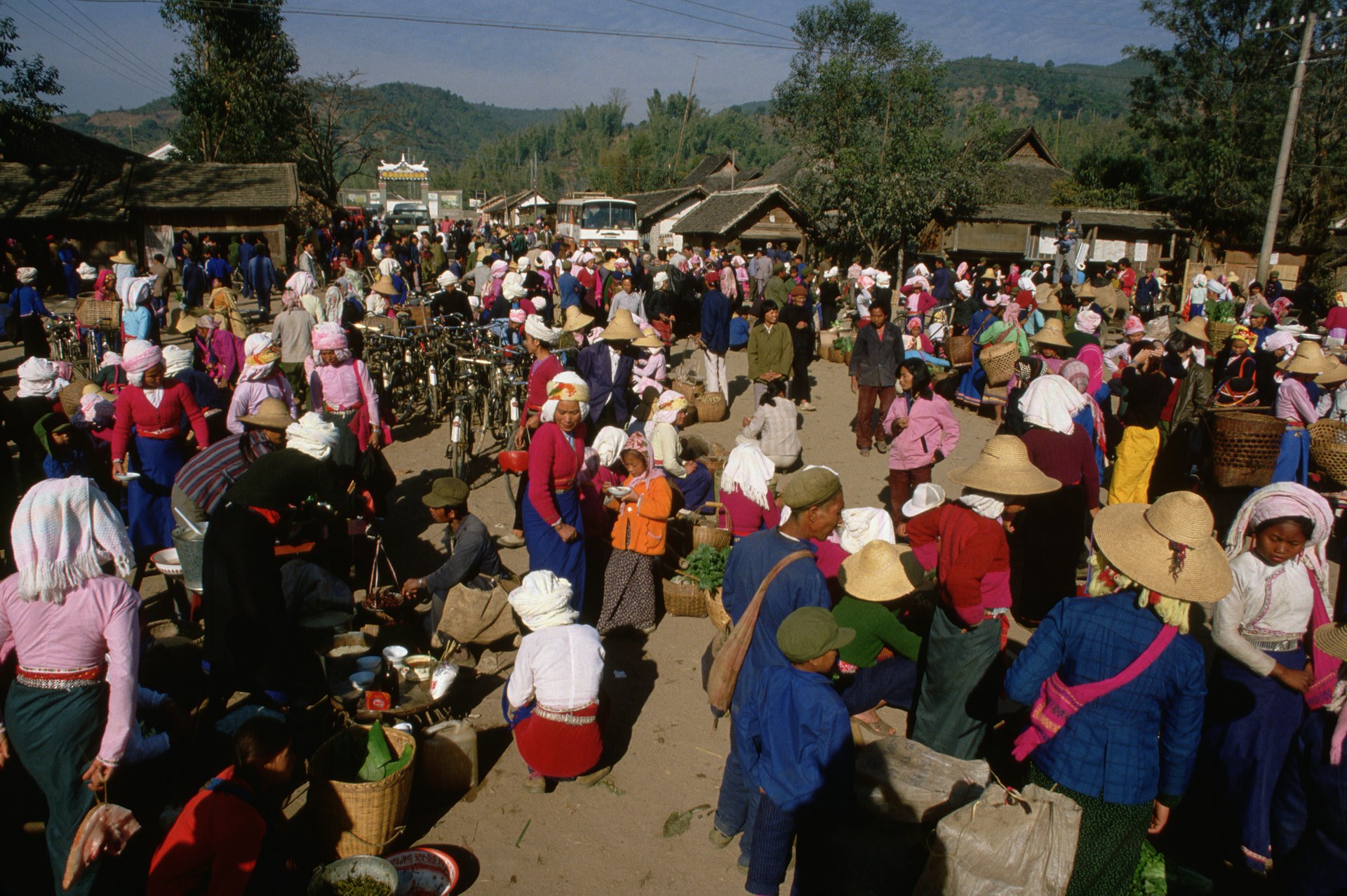 Many people in cultural dress mingle around at an outdoors market