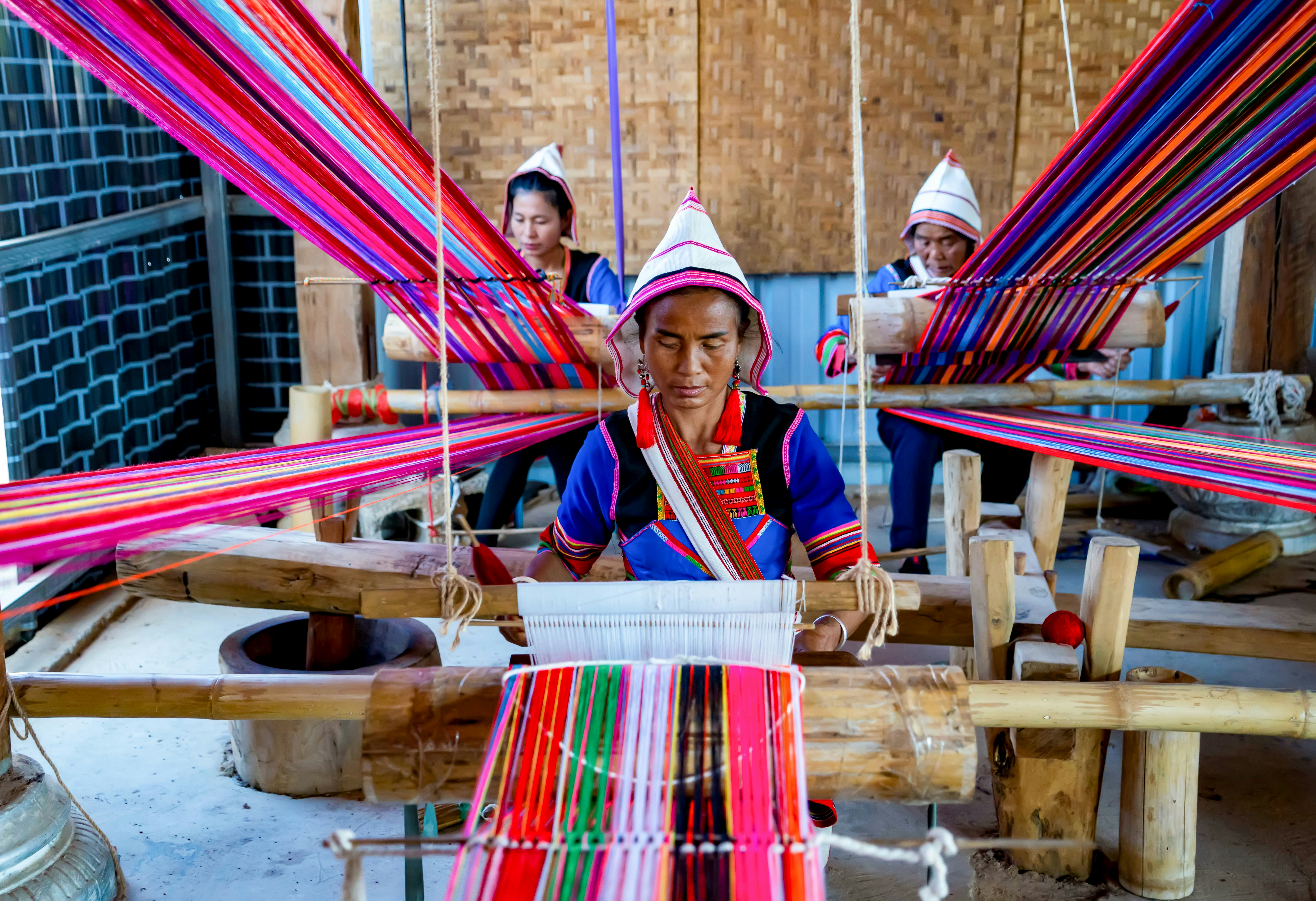 He Guiying C weaves cloths with two members of the handicraft cooperative in Xinsitu Village of Jinuo ethnic group in Jinghong City of Xishuangbanna Dai Autonomous Prefecture, southwest China's Yunnan Province