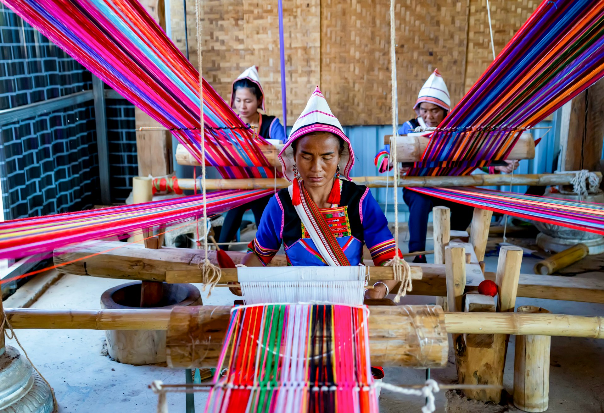 He Guiying C weaves cloths with two members of the handicraft cooperative in Xinsitu Village of Jinuo ethnic group in Jinghong City of Xishuangbanna Dai Autonomous Prefecture, southwest China's Yunnan Province