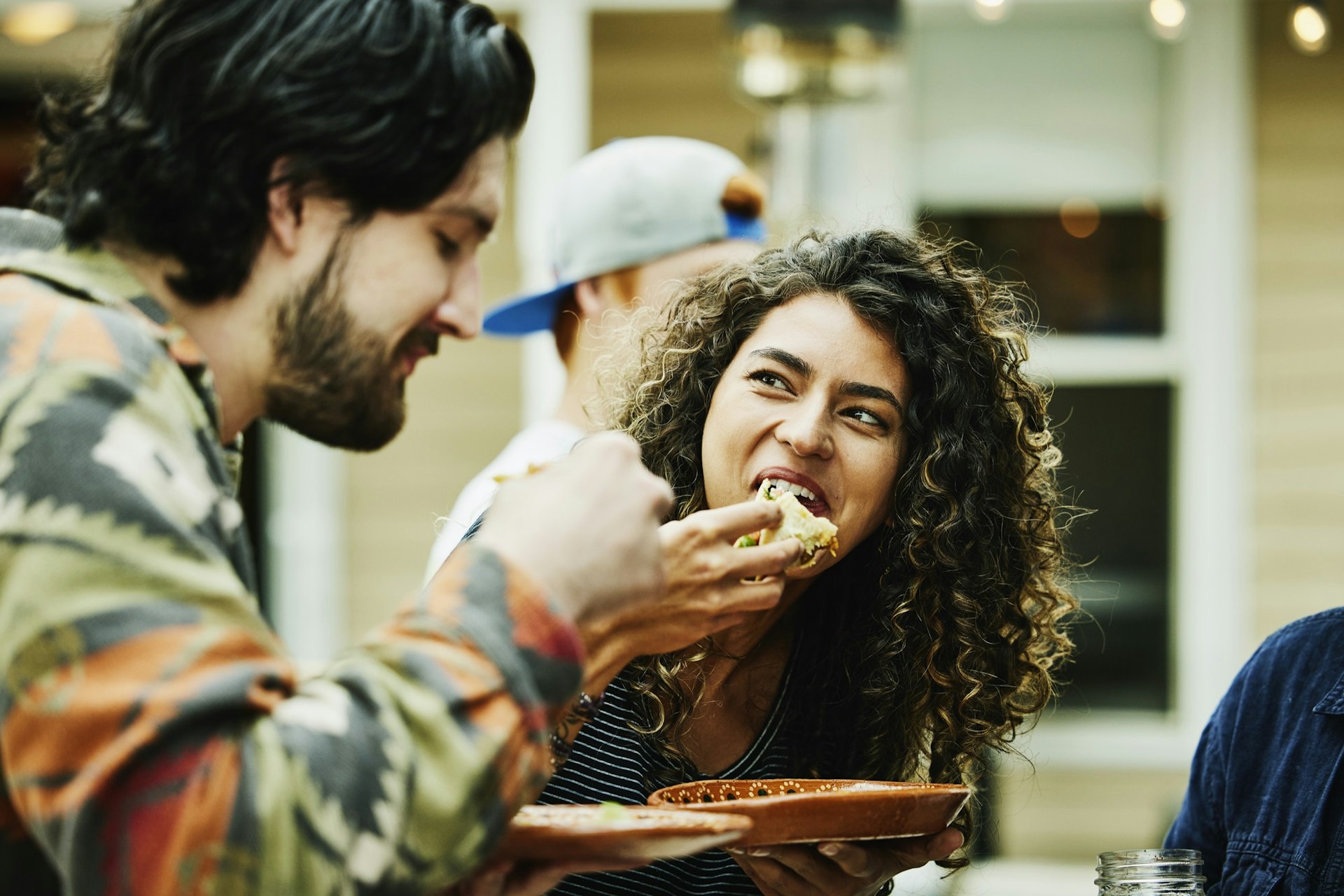 Medium close up shot of woman and man eating food