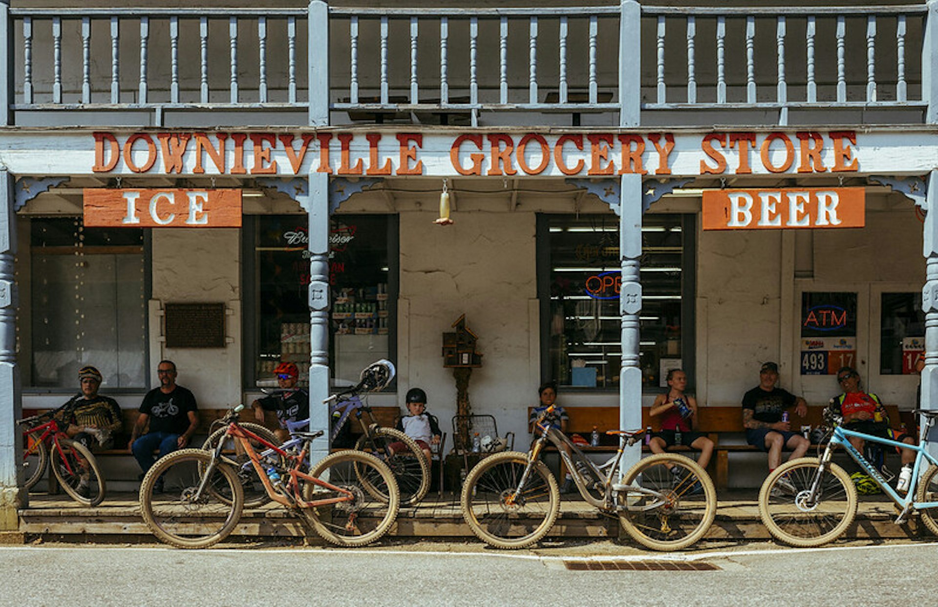 Bikers rest on benches outside Downieville Grocery Store