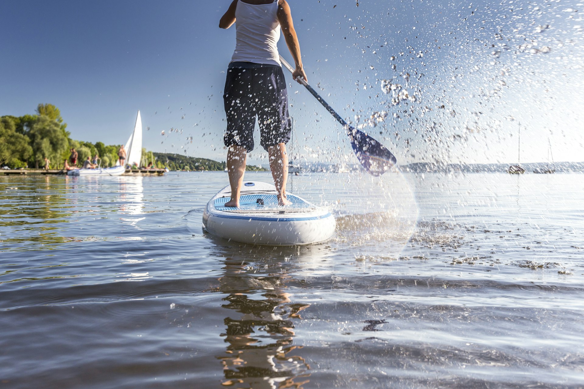 A rear shot of a person on a stand-up paddleboard on a lake