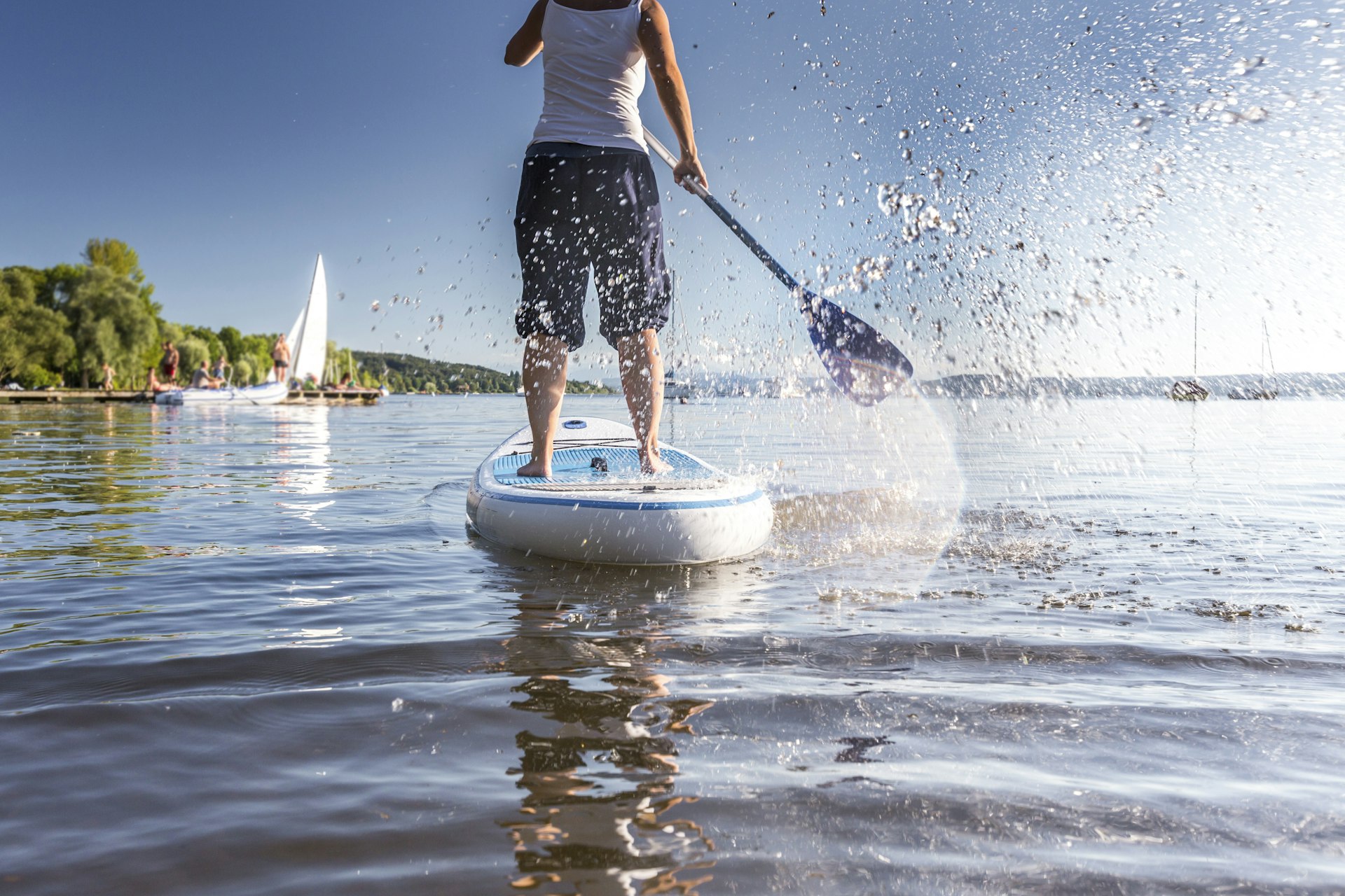 Foto traseira de uma pessoa em um stand-up paddle em um lago