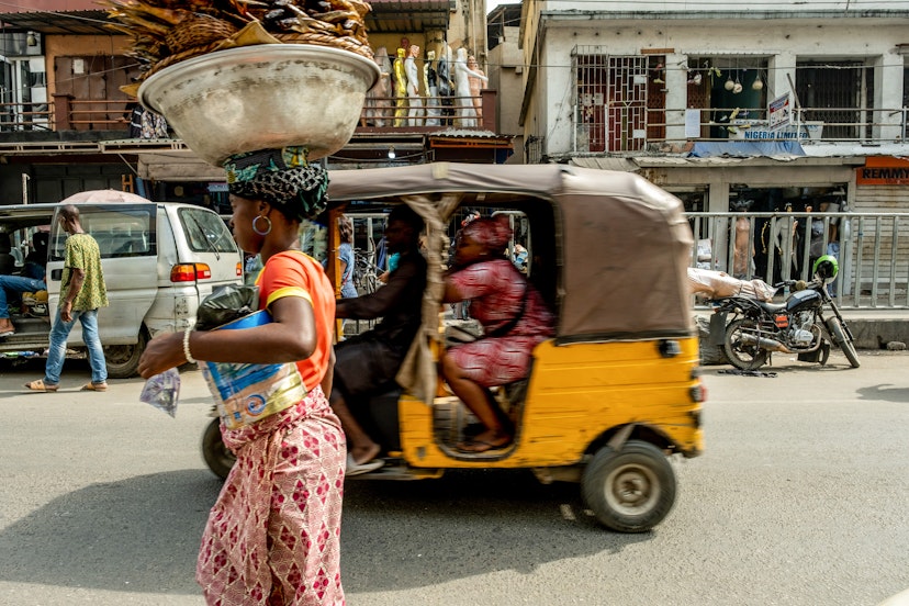 A street trader and auto rickshaw on Nnamdi Azikwe Street in Lagos, Nigeria, on Thursday, Jan. 6, 2022. Nigerias Lagos state government plans to build new roads, rail, housing, health, education and waterways infrastructure to boost businesses and improve living standards. Photographer: Adetona Omokanye/Bloomberg via Getty Images
