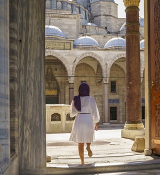 Young Muslim woman in the courtyard of Suleymaniye mosque in Istanbul, Turkey
