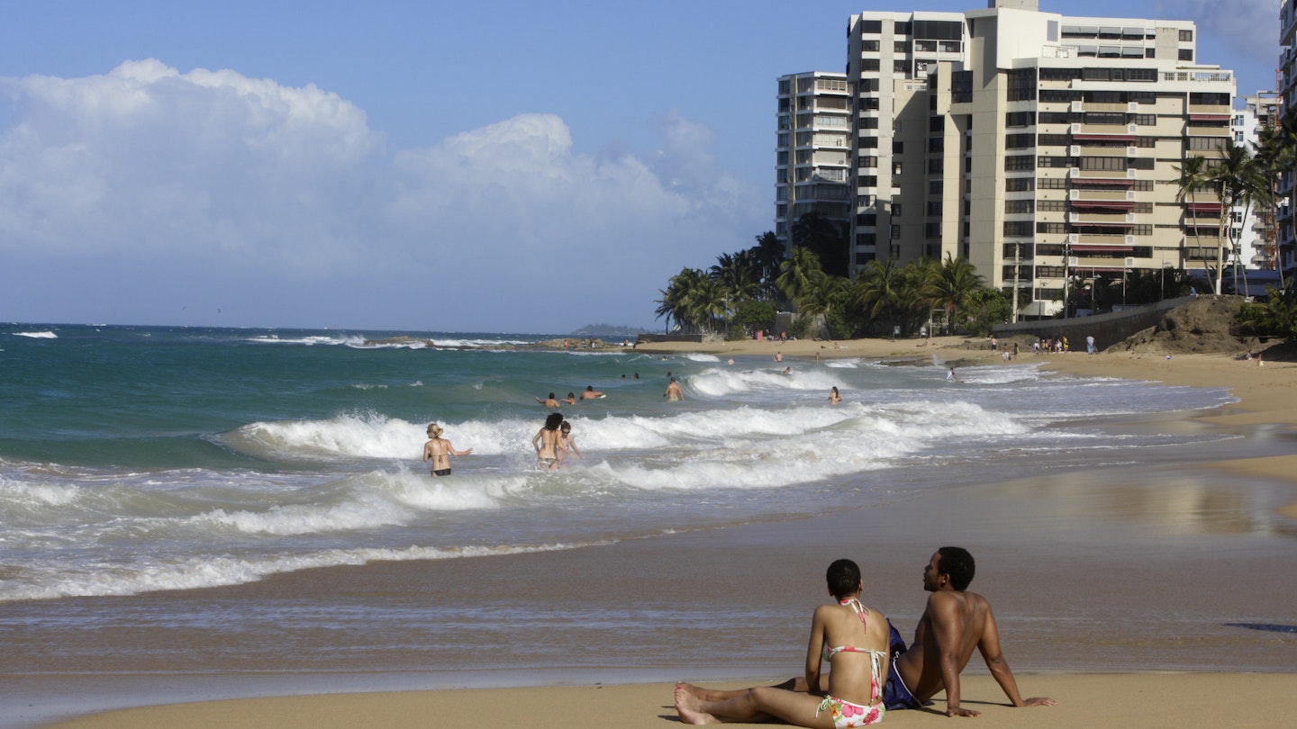 Tourists relaxing on the beach at Condado