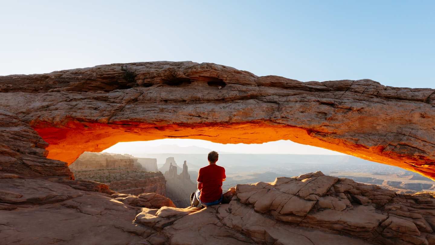 Man enjoying sunrise at Mesa arch, Canyonlands - man enjoying sunrise at Mesa arch, Canyonlands national park, Utah, USA (MR)