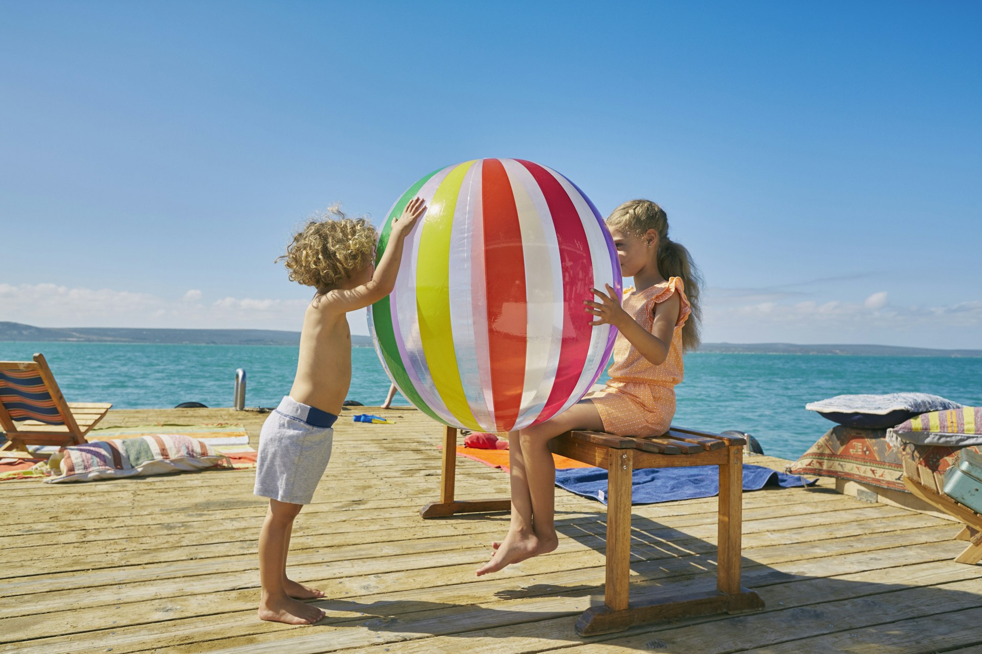 Boy and girl playing with beach ball on houseboat sun deck, Kraalbaai
