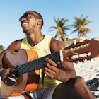 A Cuban man playing guitar on the beach